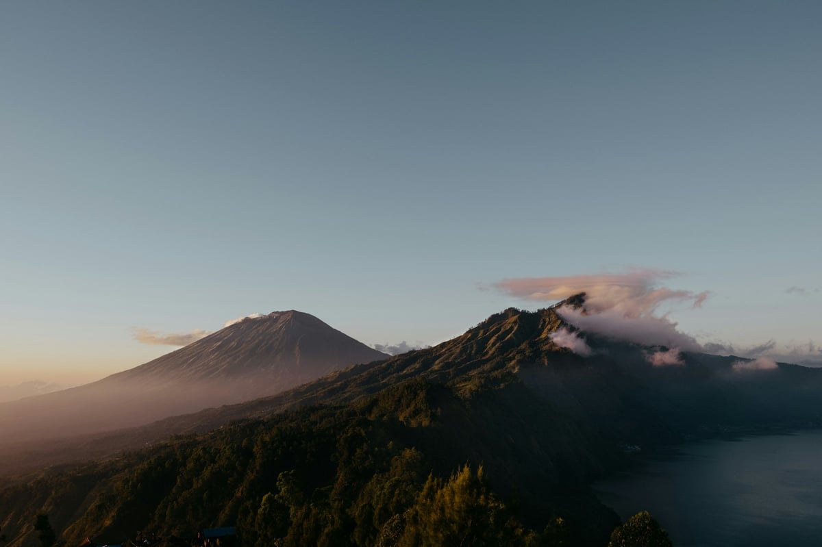 A volcano rising above mist and forested ridges in Bali