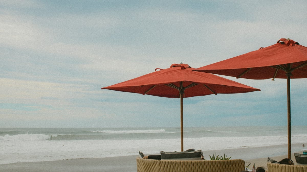 Red umbrellas over seats facing the sea in Bali