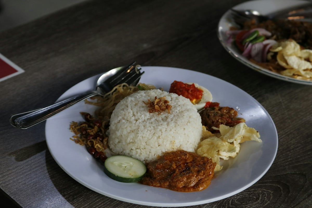 A plate of rice with sambal and side dishes