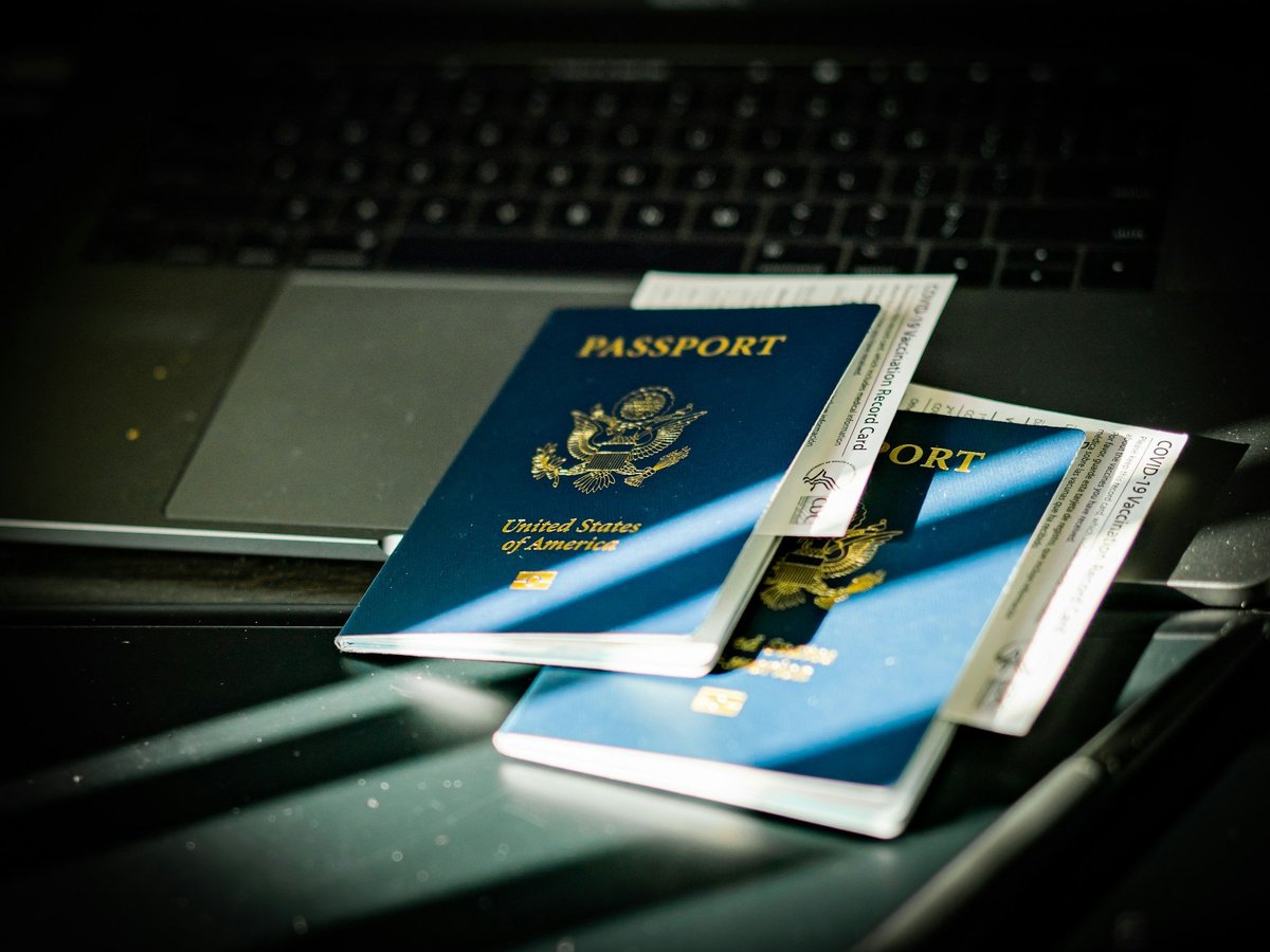 Two US passports resting on a laptop keyboard