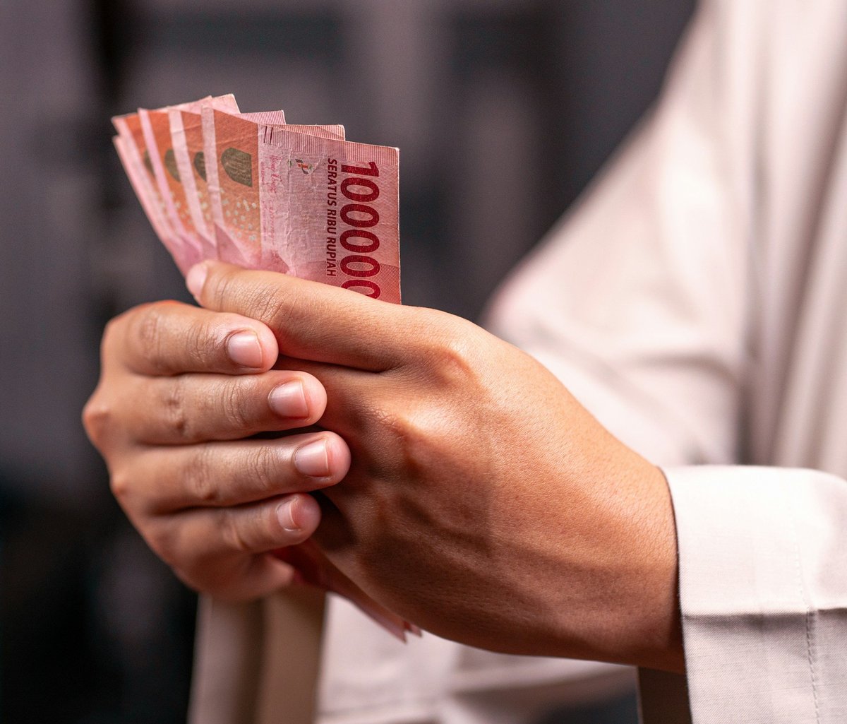 Hands counting Indonesian rupiah banknotes