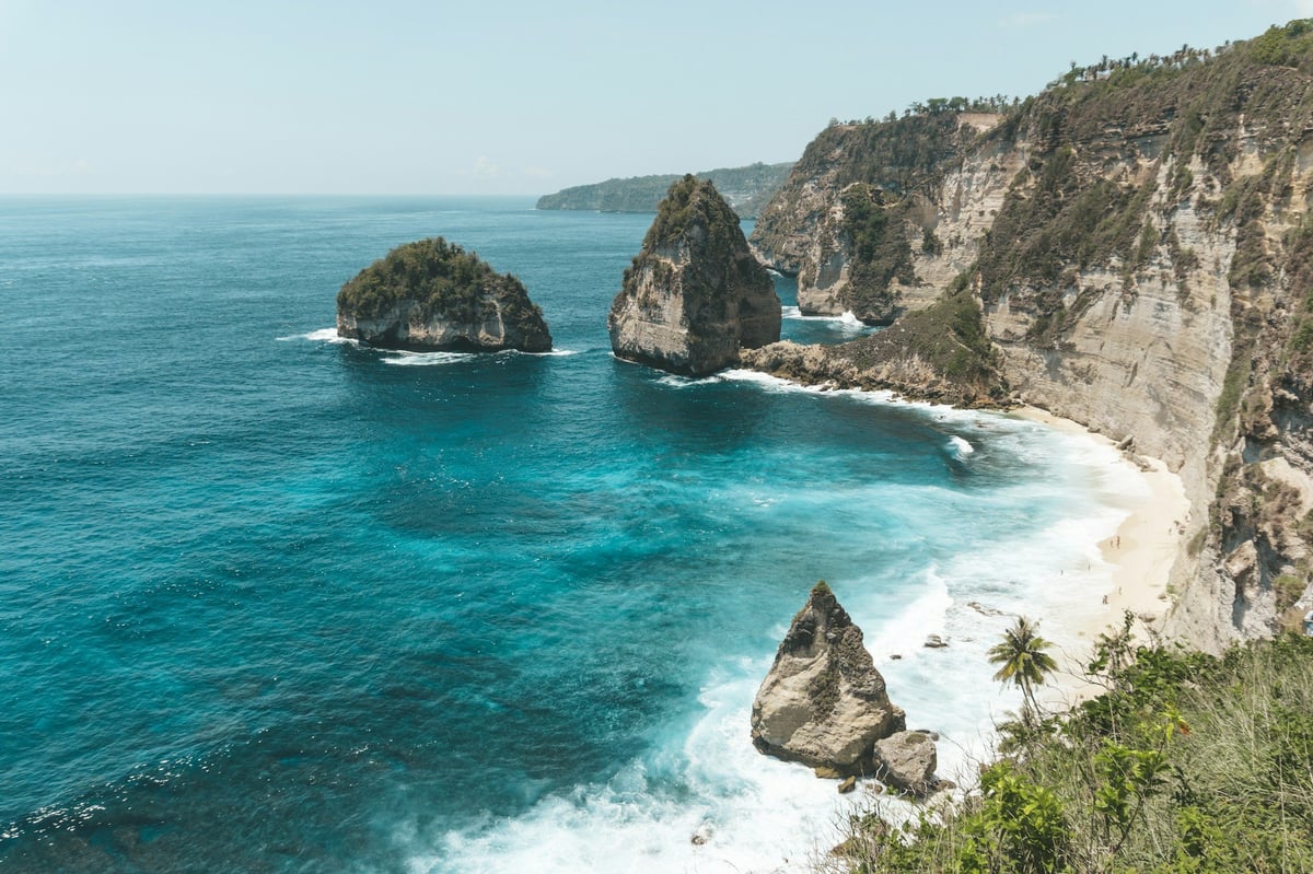 Rock stacks and a white beach below cliffs on Nusa Penida
