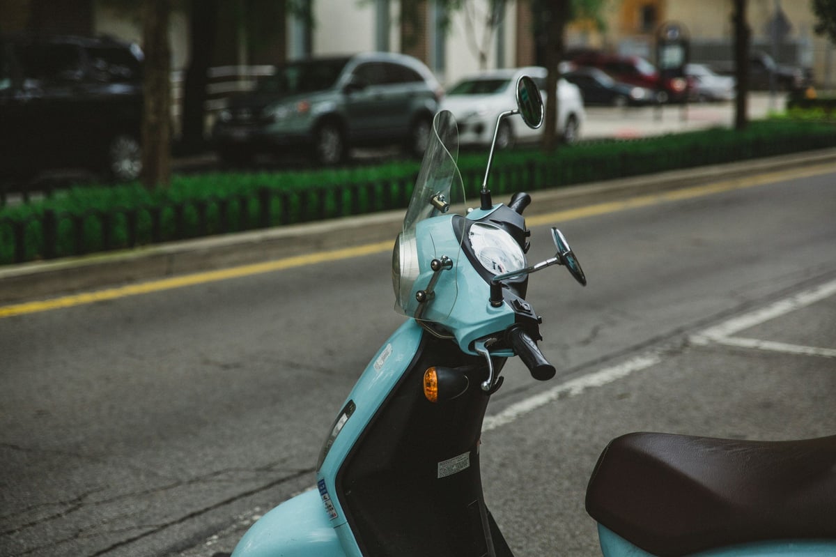 Rental scooters parked in a row on a street in Bali