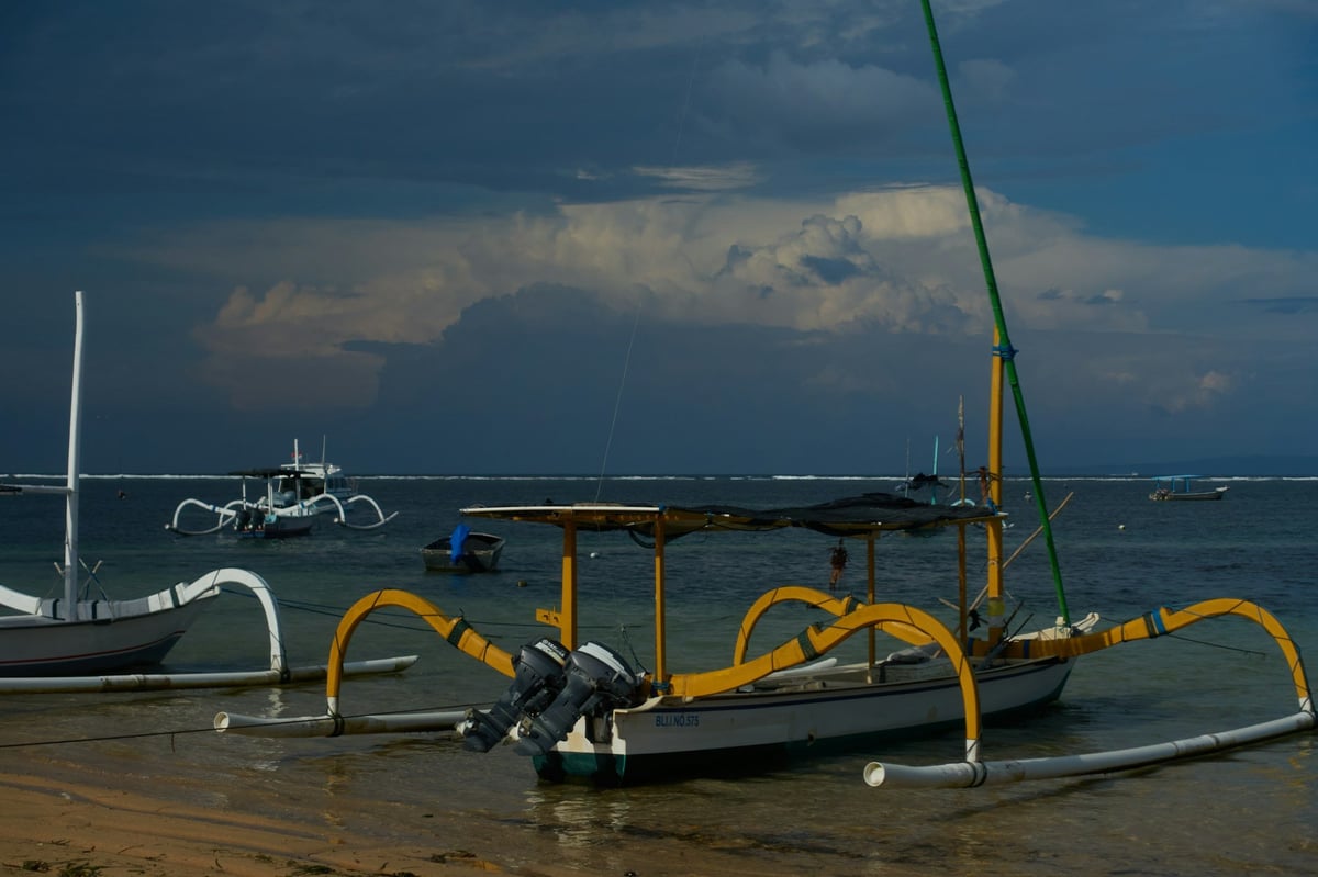 Outrigger fishing boats moored off a beach in East Bali