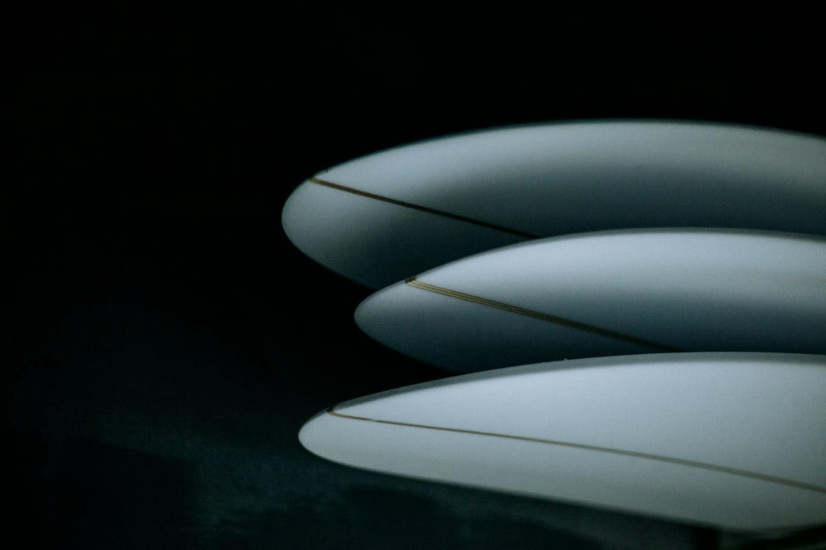Three surfboards stacked side by side