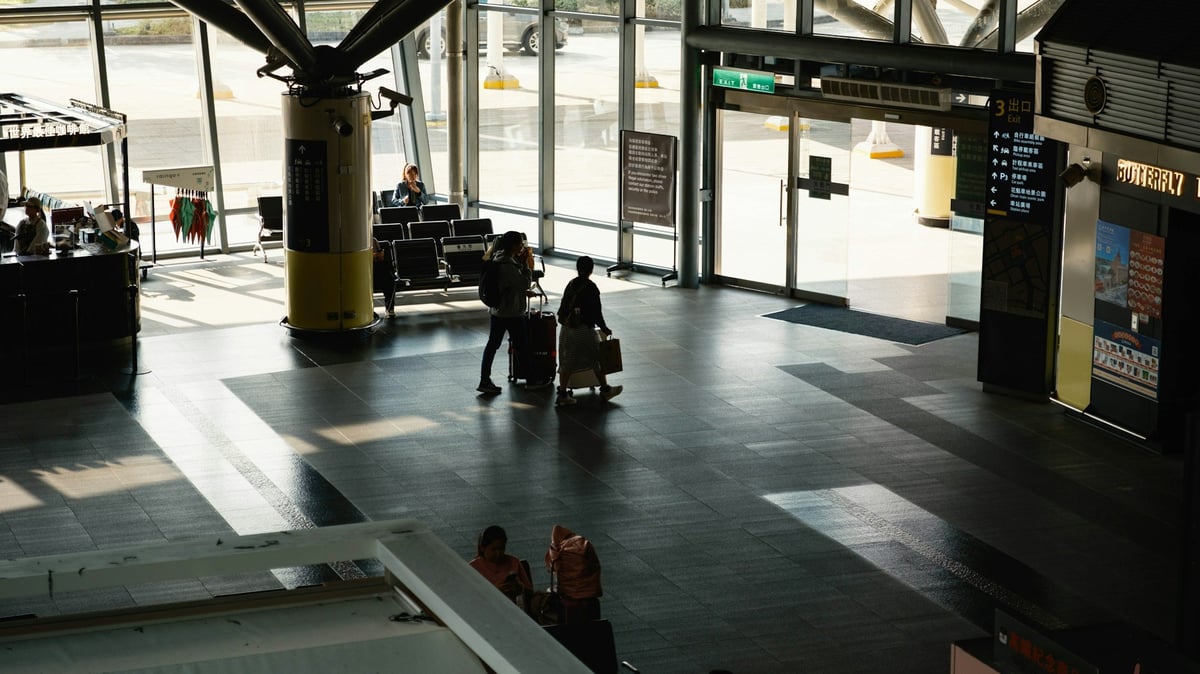 Travelers in silhouette crossing an airport terminal
