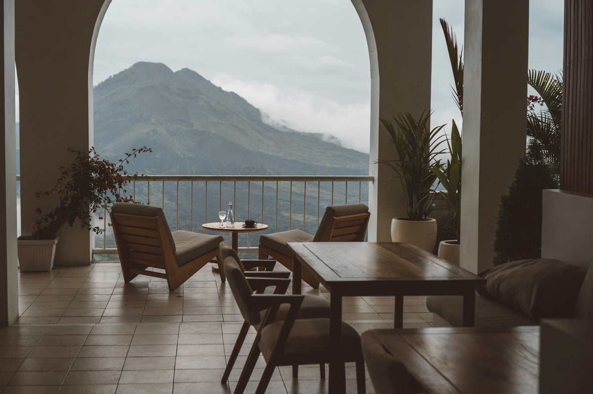 A cafe terrace table with a view of a volcano in Bali