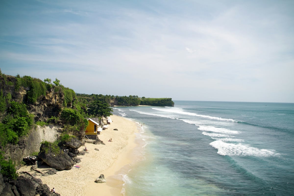 A white sand beach below cliffs on the Bukit peninsula