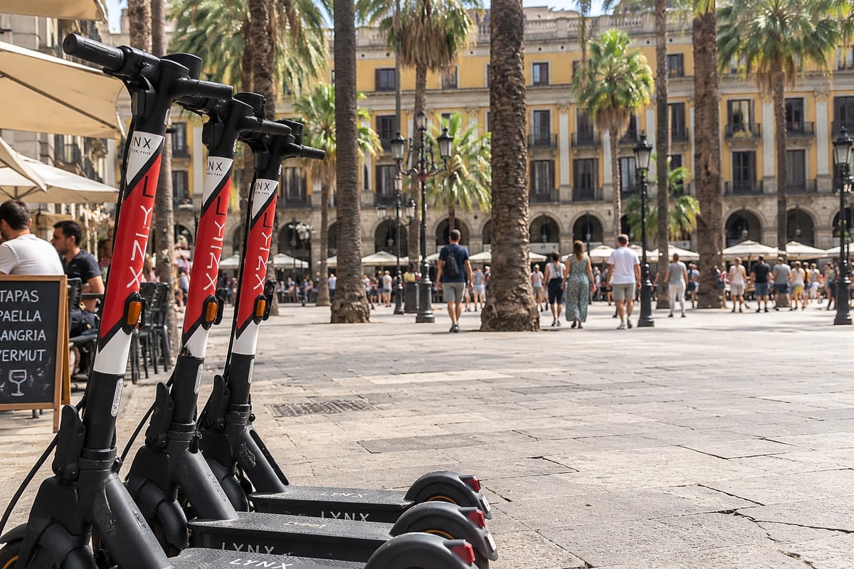 A row of shared e-scooters parked in a designated Barcelona parking zone