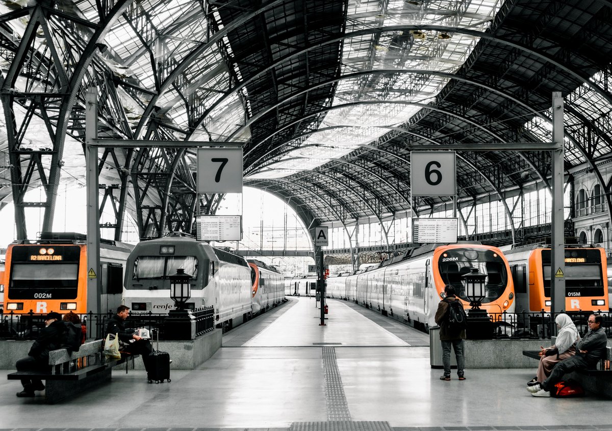 A sleek Spanish high-speed train at a platform, or the Barcelona Sants concourse