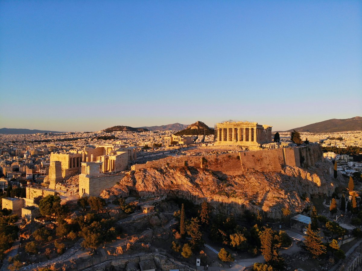 A bright, aspirational shot blending Athens and a Cycladic island