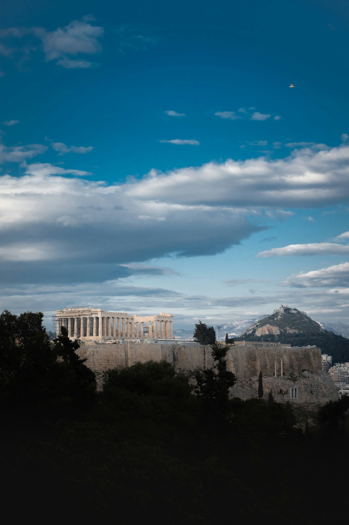 Split-feel image — the Acropolis and the Santorini caldera