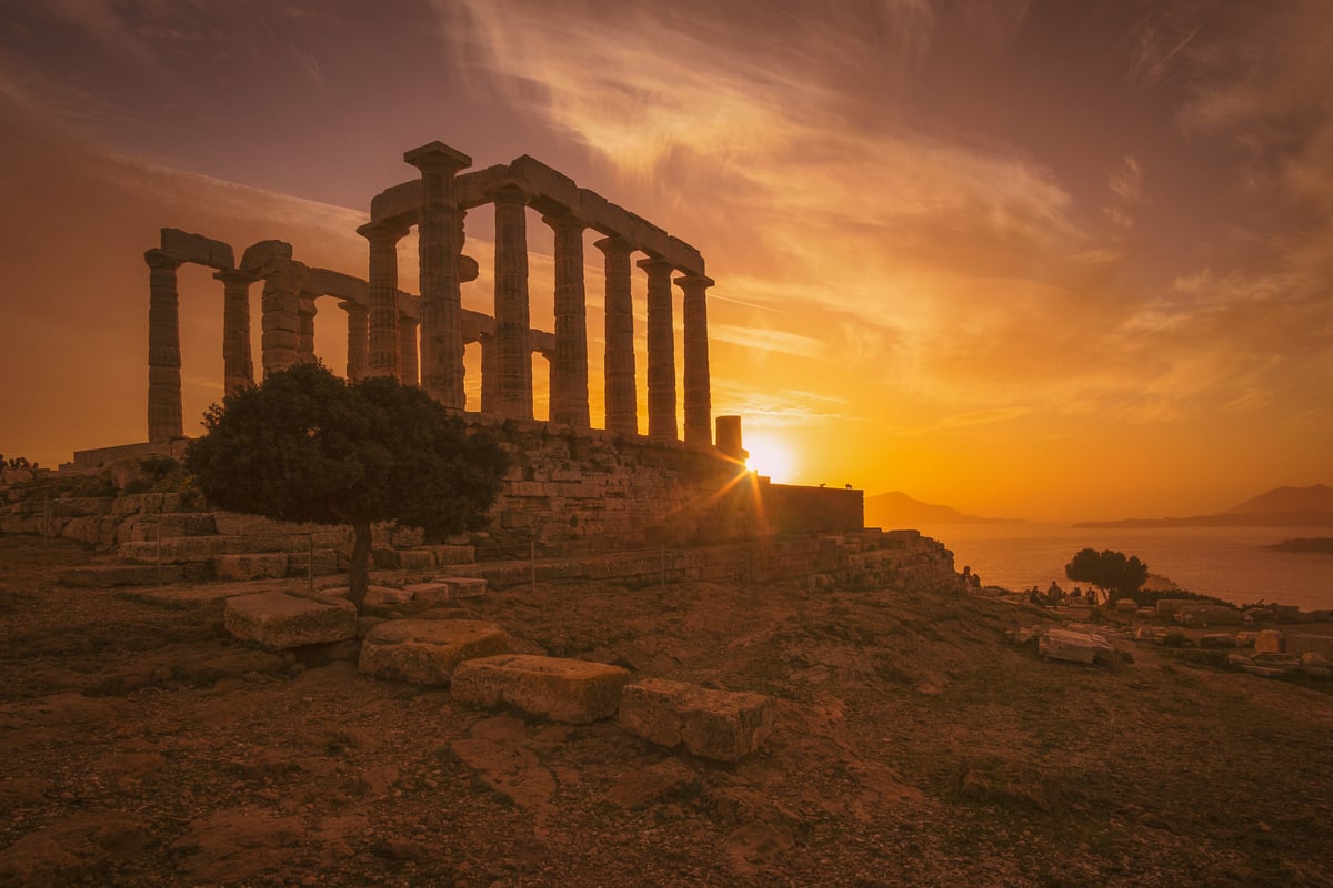 The Temple of Poseidon at Cape Sounion at sunset, columns above the sea