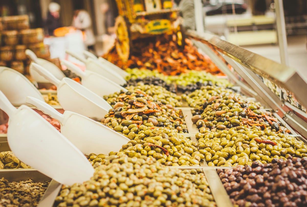 Colorful stalls of olives, cheeses, and spices at an Athens market