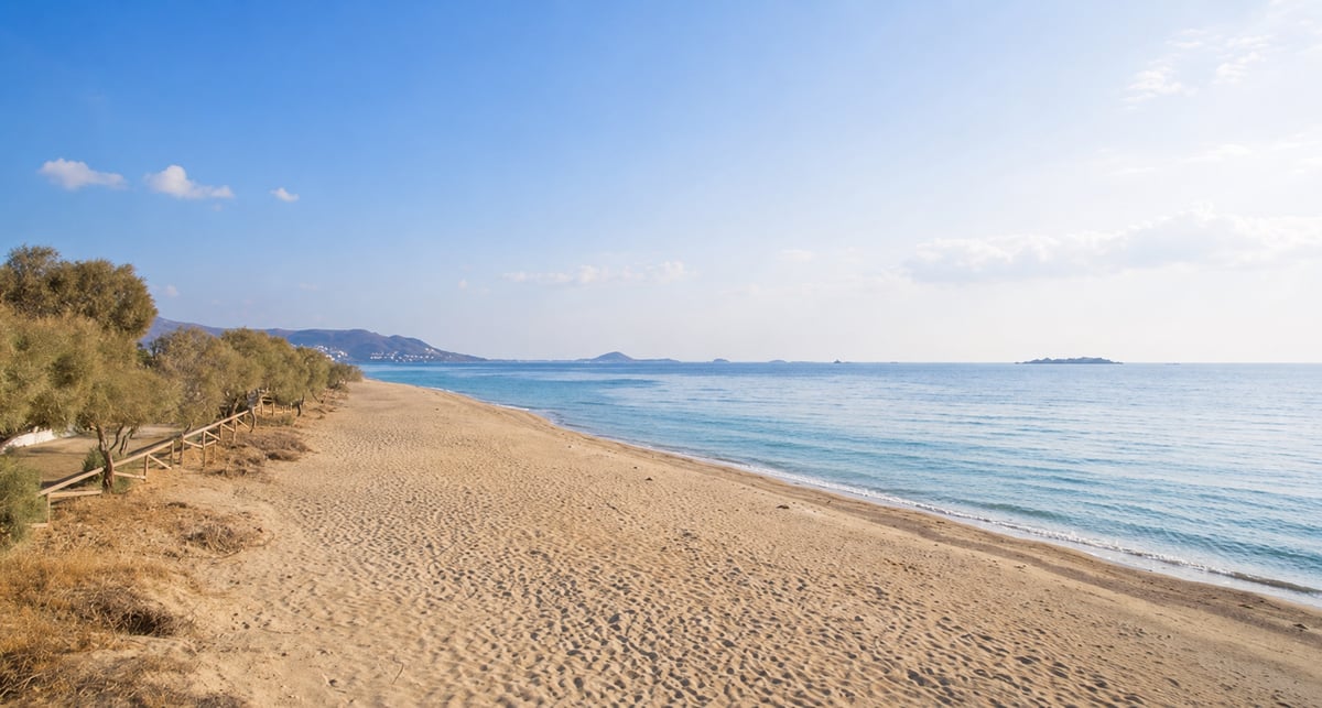 A long golden sandy Naxos beach with shallow turquoise water