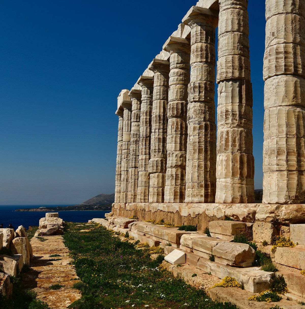 The Temple of Poseidon at Cape Sounion on its clifftop above the blue Aegean