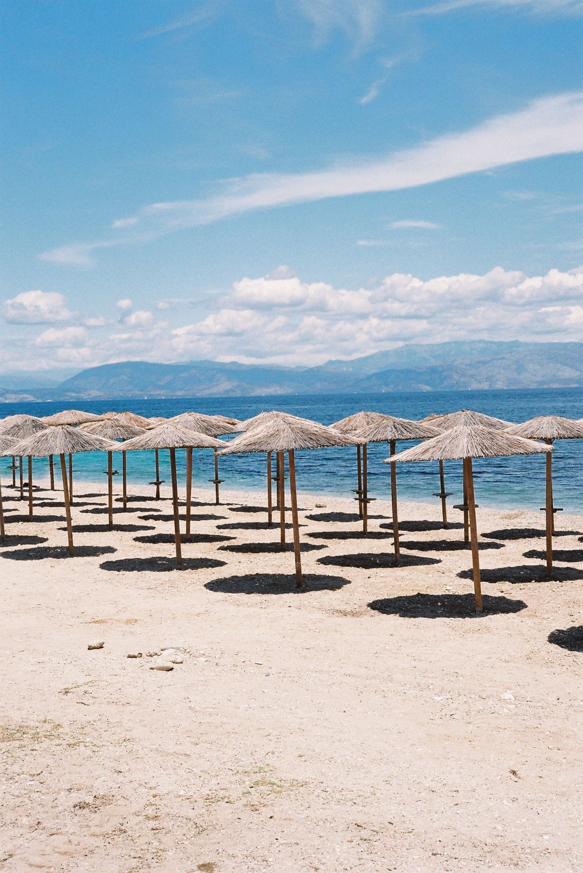A relaxed, uncrowded Greek island scene in shoulder season — quiet harbor or beach