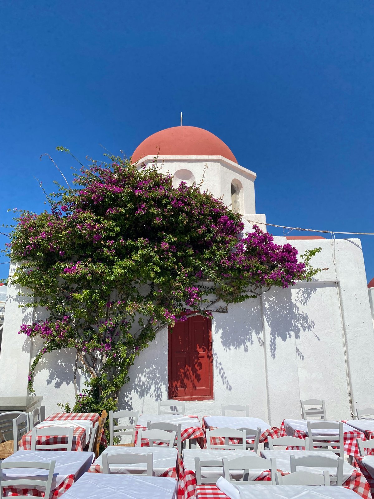 A traditional Greek taverna with outdoor tables under a canopy