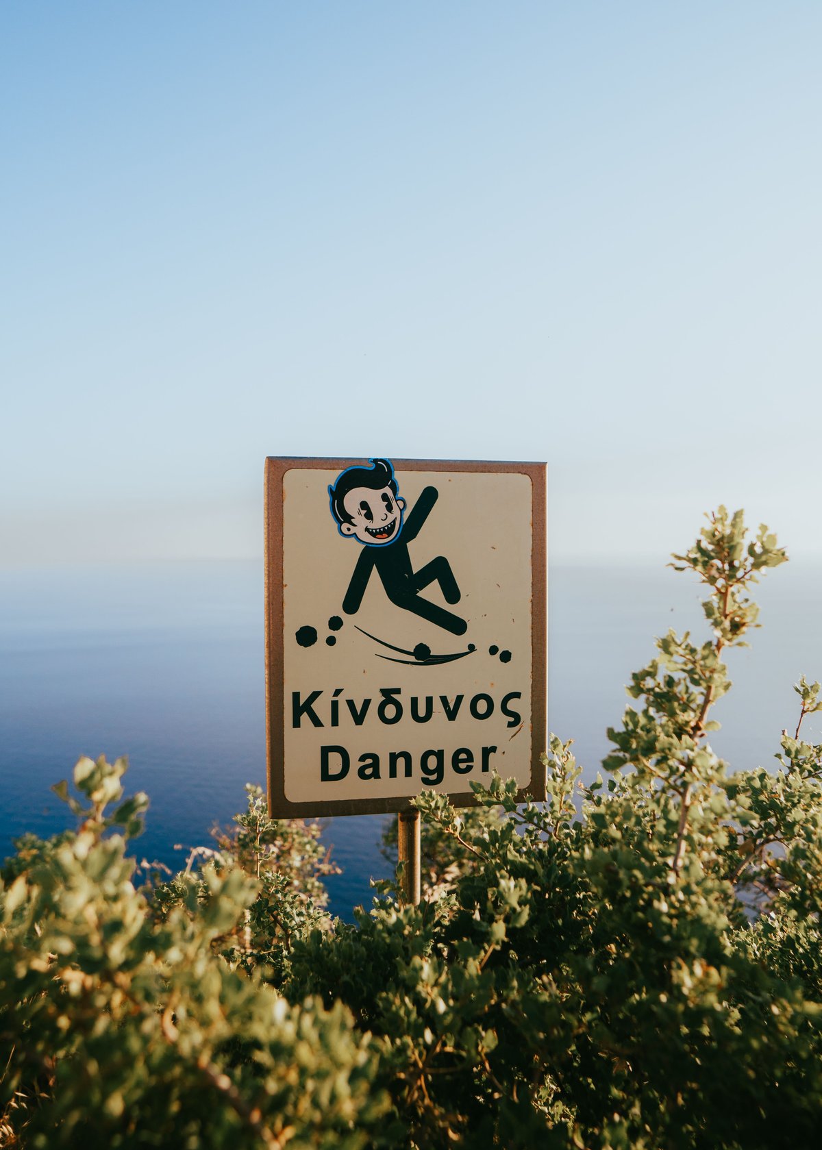 A scenic but winding Greek island road, or a beach with safety flags