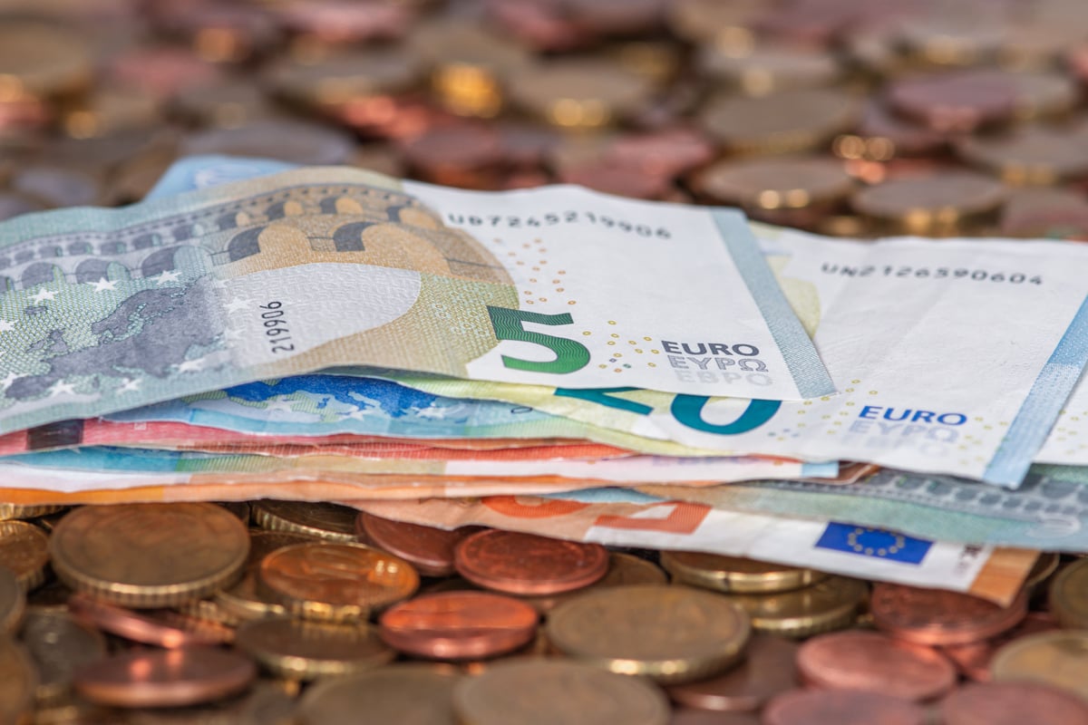 Euro banknotes and coins, or a card payment at a Greek café