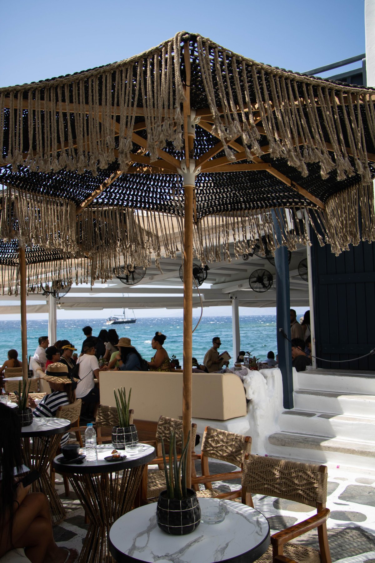 A Mykonos beach club party scene in golden afternoon light