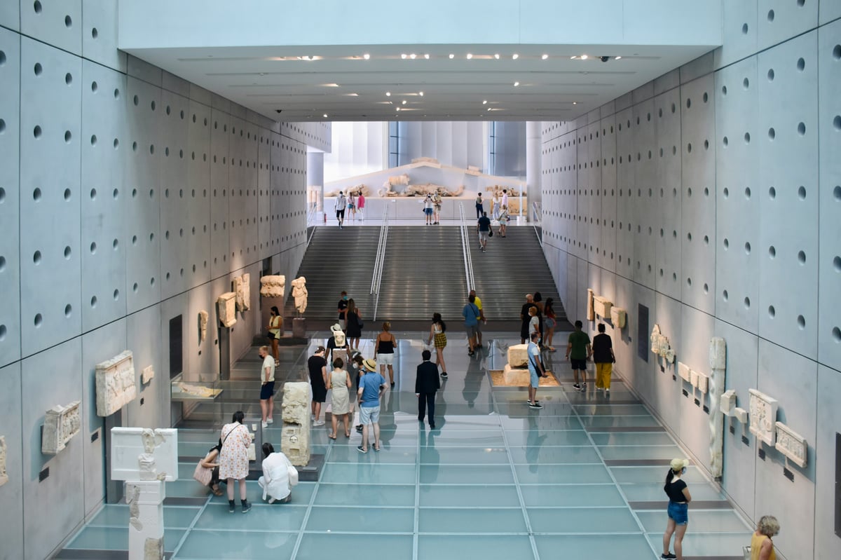 Interior of the Acropolis Museum, sculptures with the Parthenon visible through glass