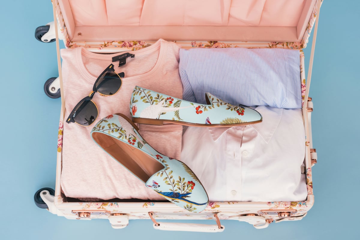 A neatly packed travel bag with summer essentials laid out