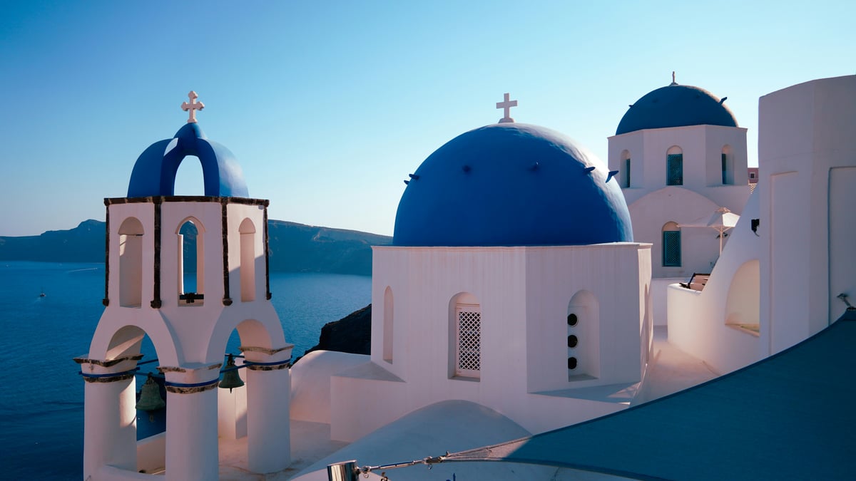 Fira town at dusk, cable car and caldera, lights coming on