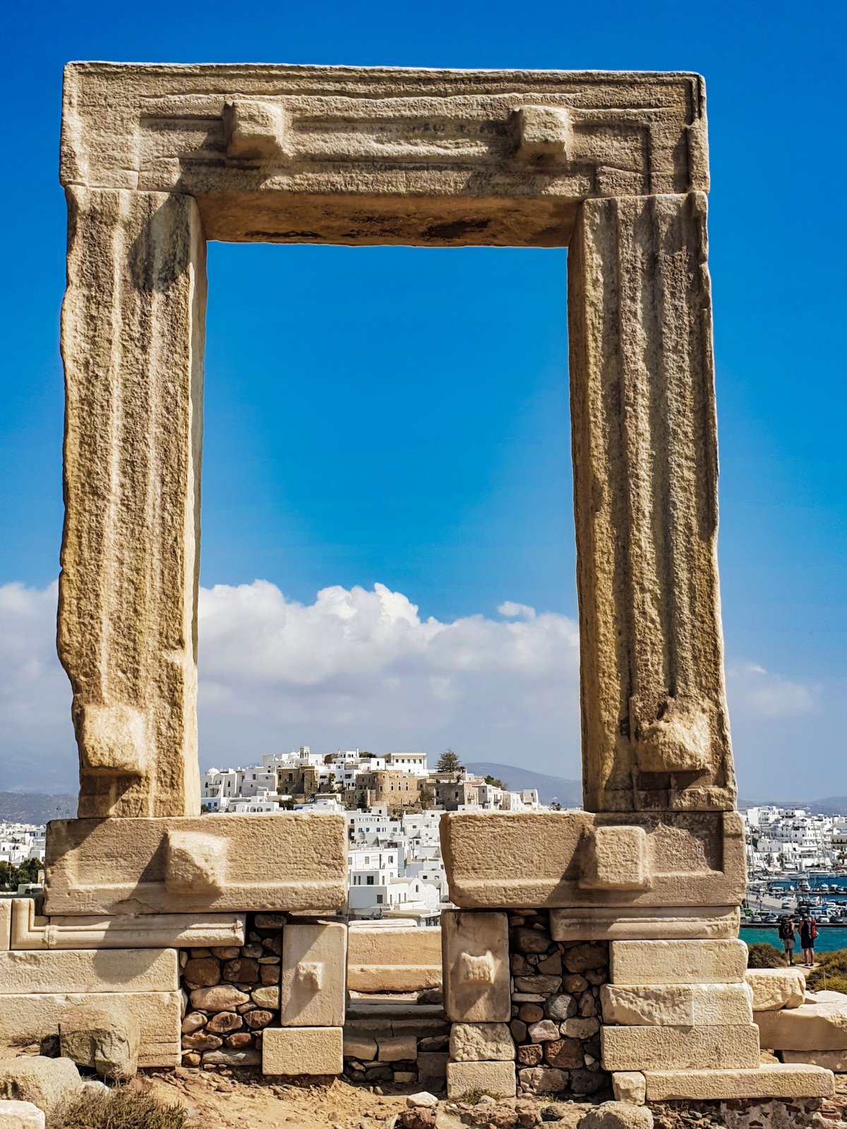 Naxos Chora with the Portara marble gateway at sunset, harbor in view