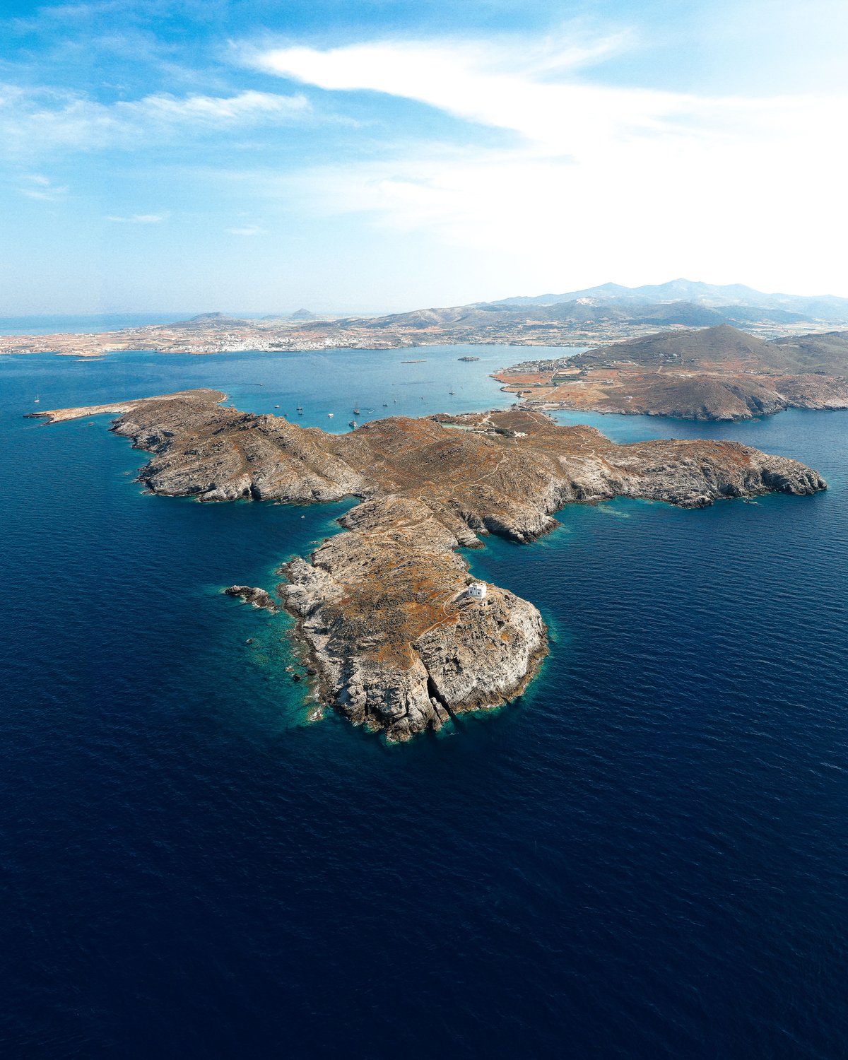 A map-like aerial of Cycladic islands scattered across blue Aegean sea