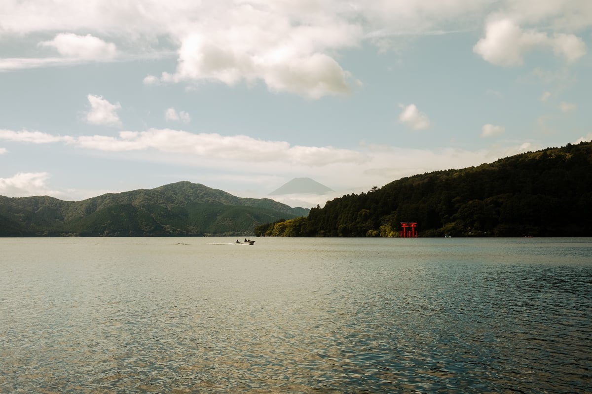 Mt Fuji seen across Lake Ashi with a red torii gate in Hakone