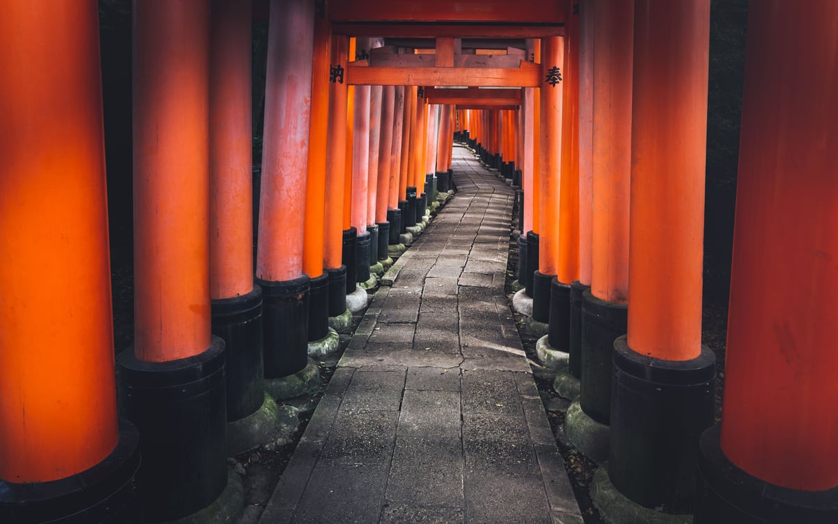 An empty vermilion torii gate tunnel at Fushimi Inari Taisha