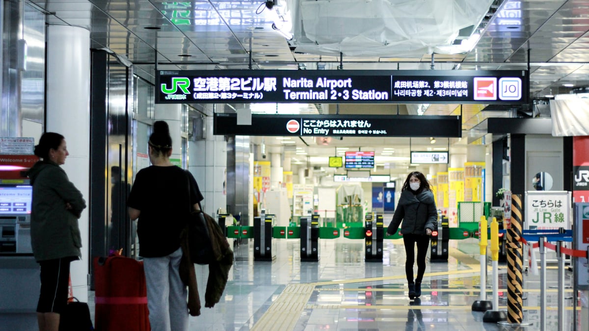 Travelers walking through a Narita Airport terminal in Japan