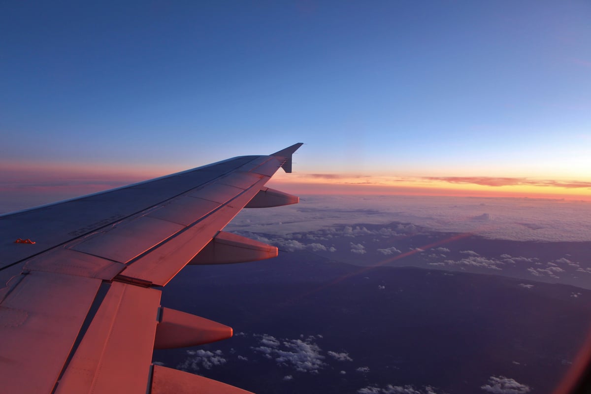 Airplane wing view at sunset during a long-haul flight to Japan