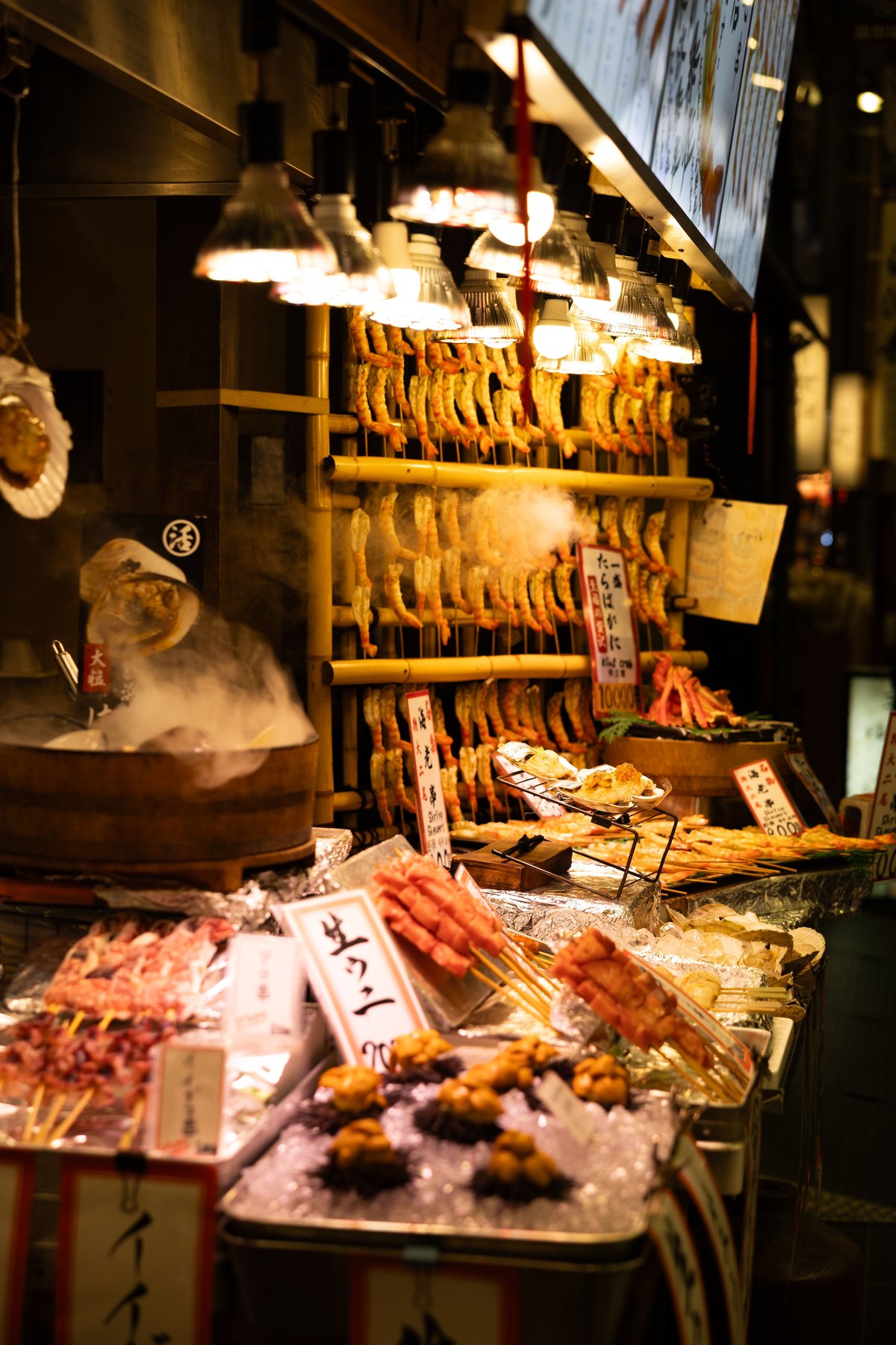 A Japanese street food stall with grilled skewers and seafood on display