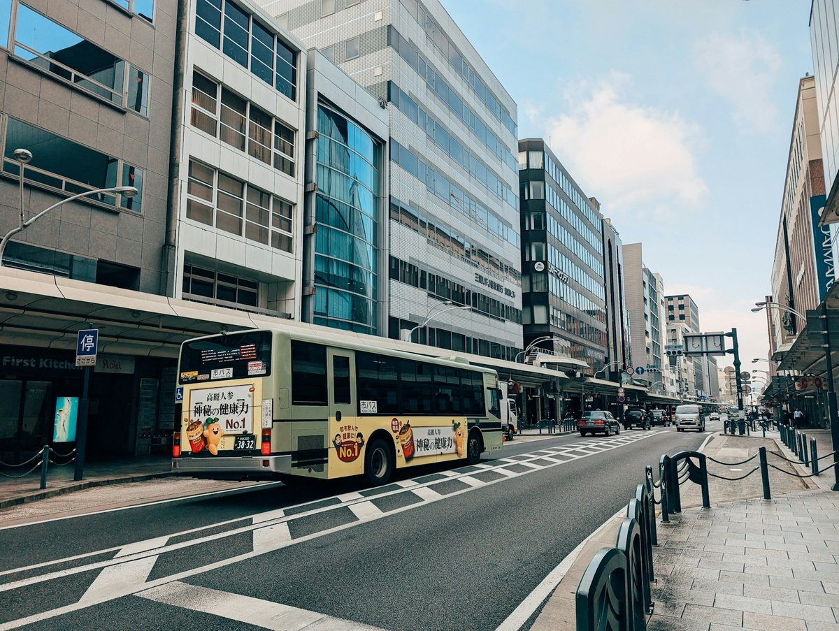 Yellow Kyoto city bus on an ordinary street, daylight