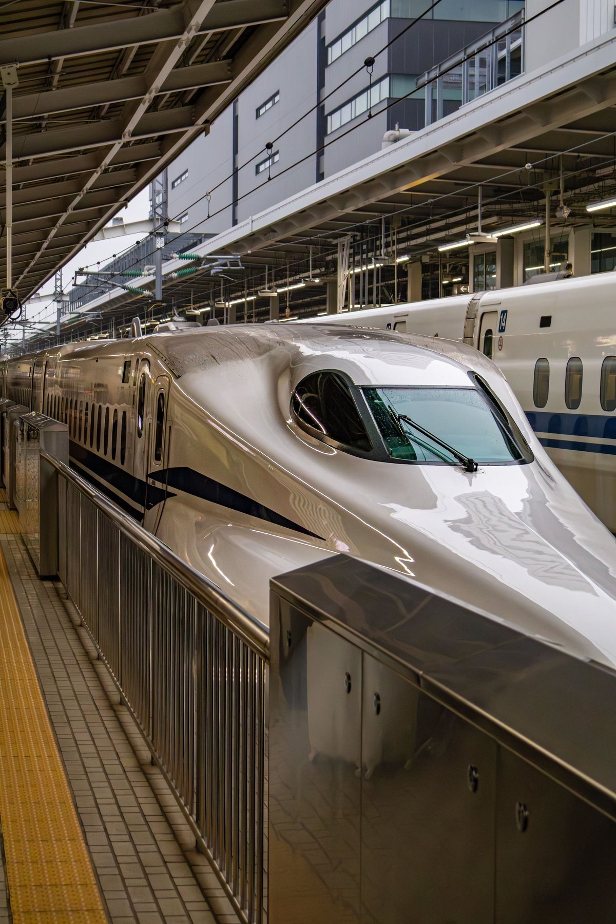 A Shinkansen bullet train departing a station platform