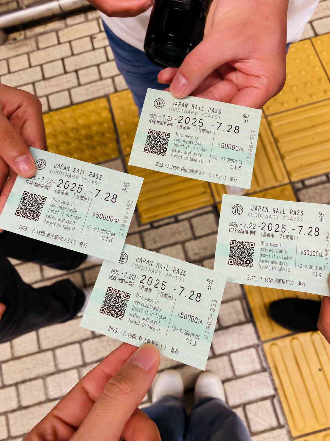 Four Japan Rail Pass ordinary tickets held in hand at a station