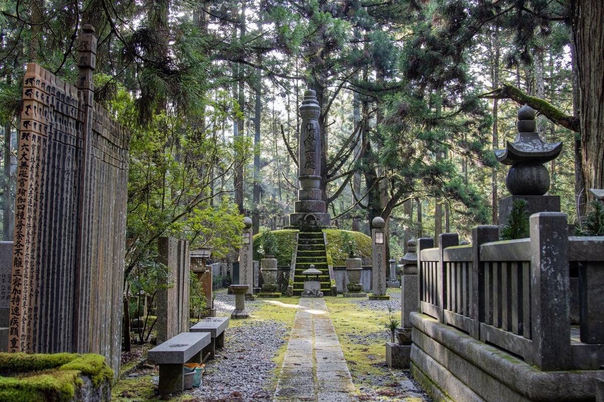 The Okunoin cemetery path at Koyasan, moss-covered stone lanterns among towering cedars