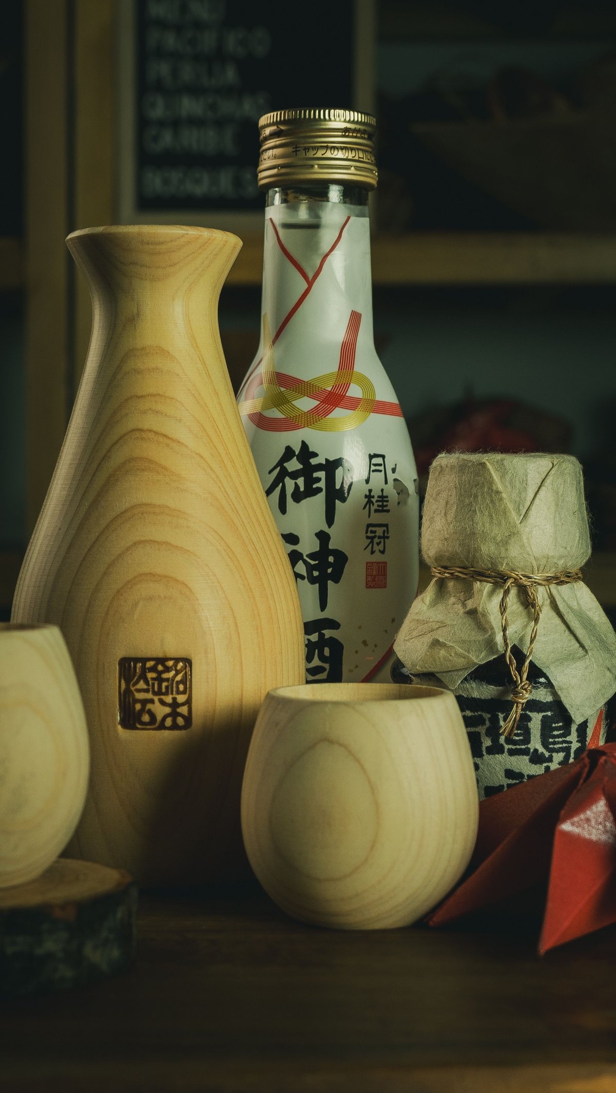 A bottle of sake with small wooden cups on a table