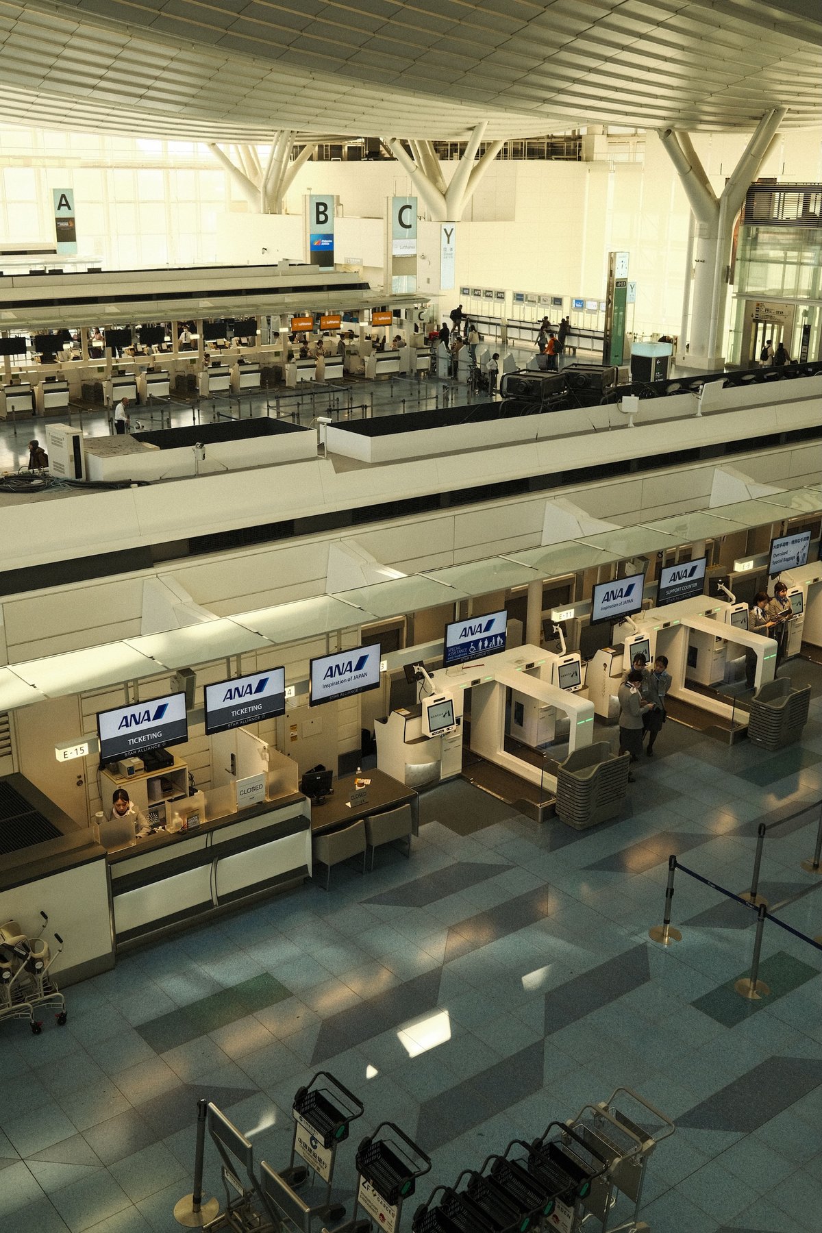 Airline check-in counters inside a spacious modern airport terminal
