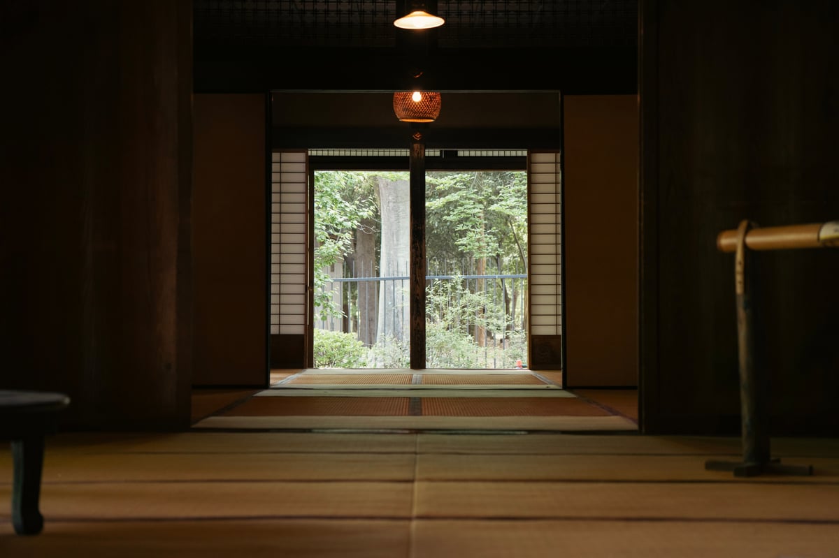 A traditional ryokan tatami room opening onto a green garden view