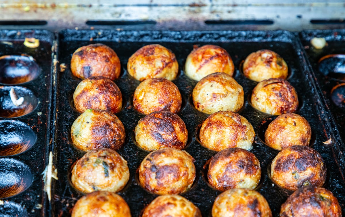 Freshly grilled takoyaki octopus balls on a teppan griddle