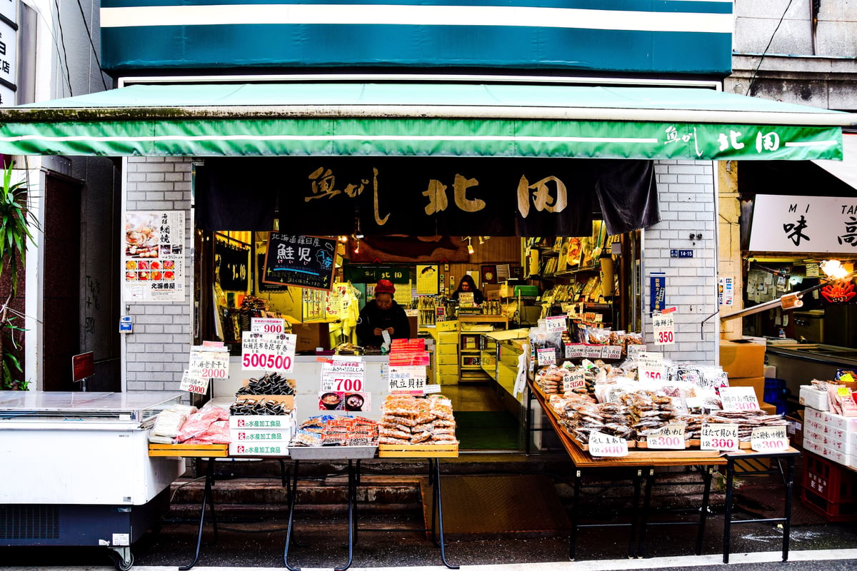 A seafood market stall with fresh products and price signs
