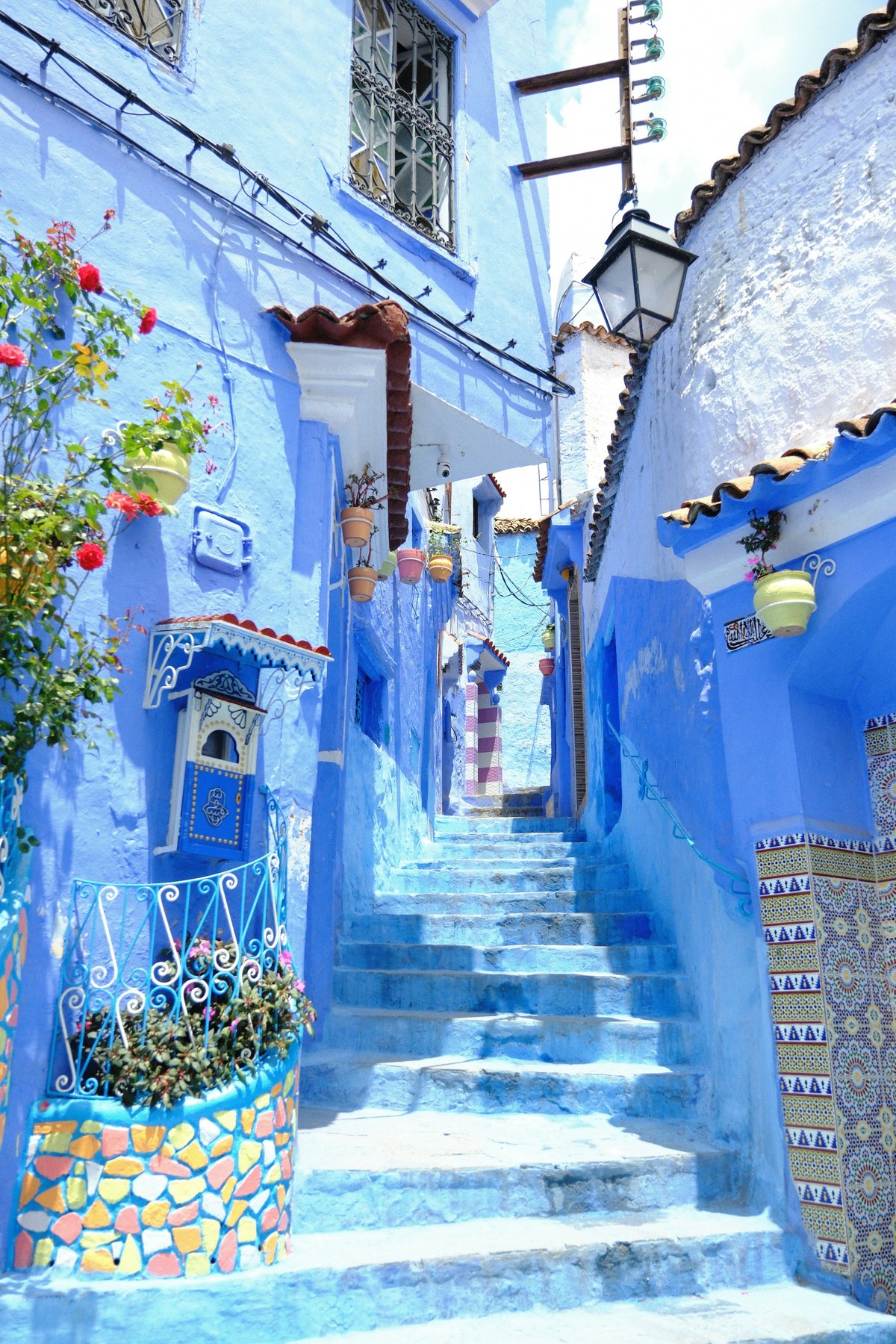 The blue-washed streets of Chefchaouen with a person walking a narrow lane