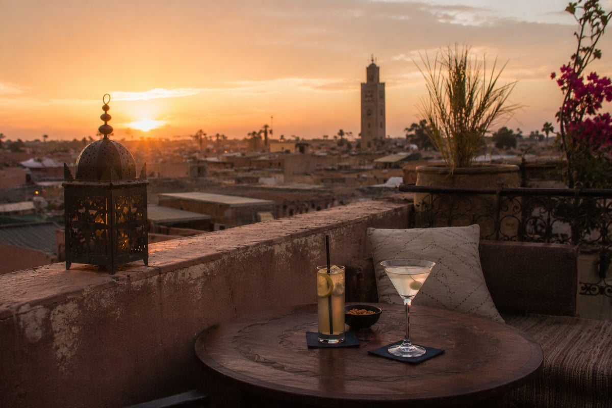 A rooftop bar table overlooking a Moroccan city at sunset, no faces