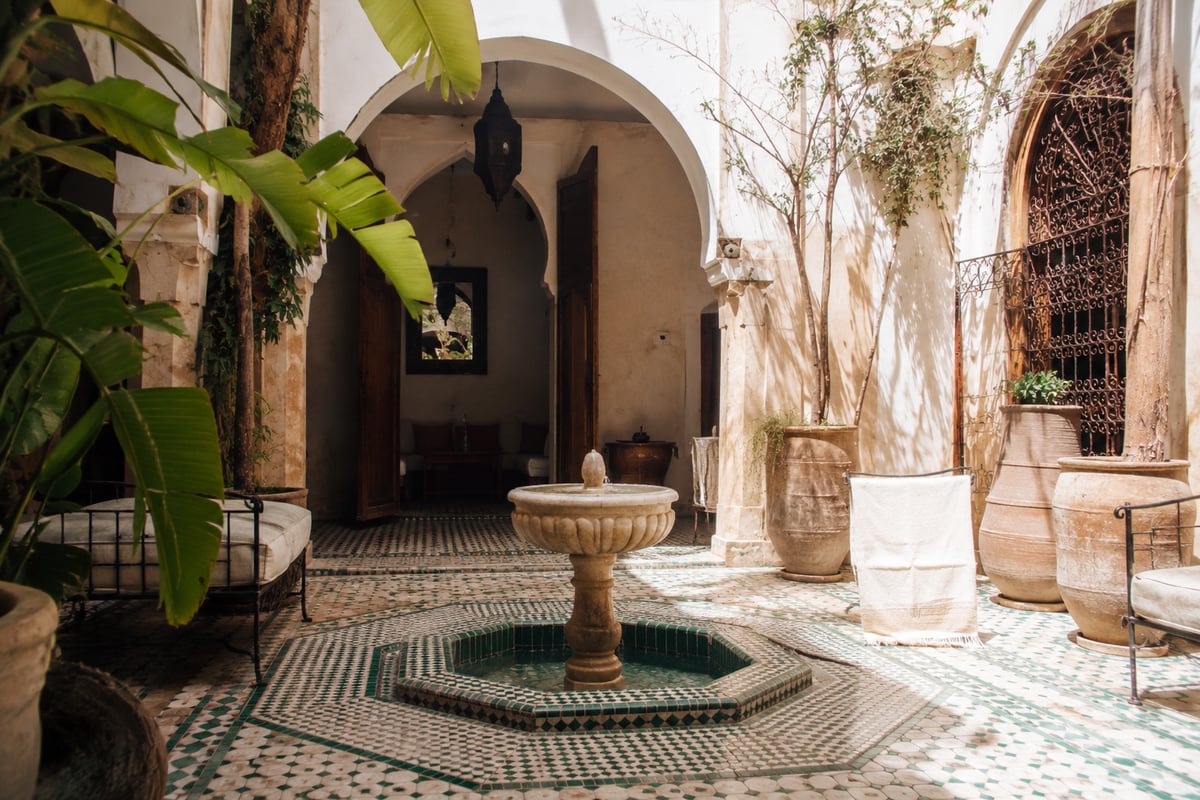 A Marrakech riad courtyard with a fountain and tilework, no faces