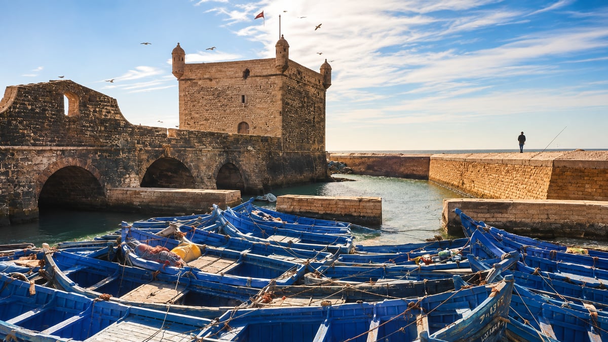 The ramparts and harbour of Essaouira with blue fishing boats, no clear faces