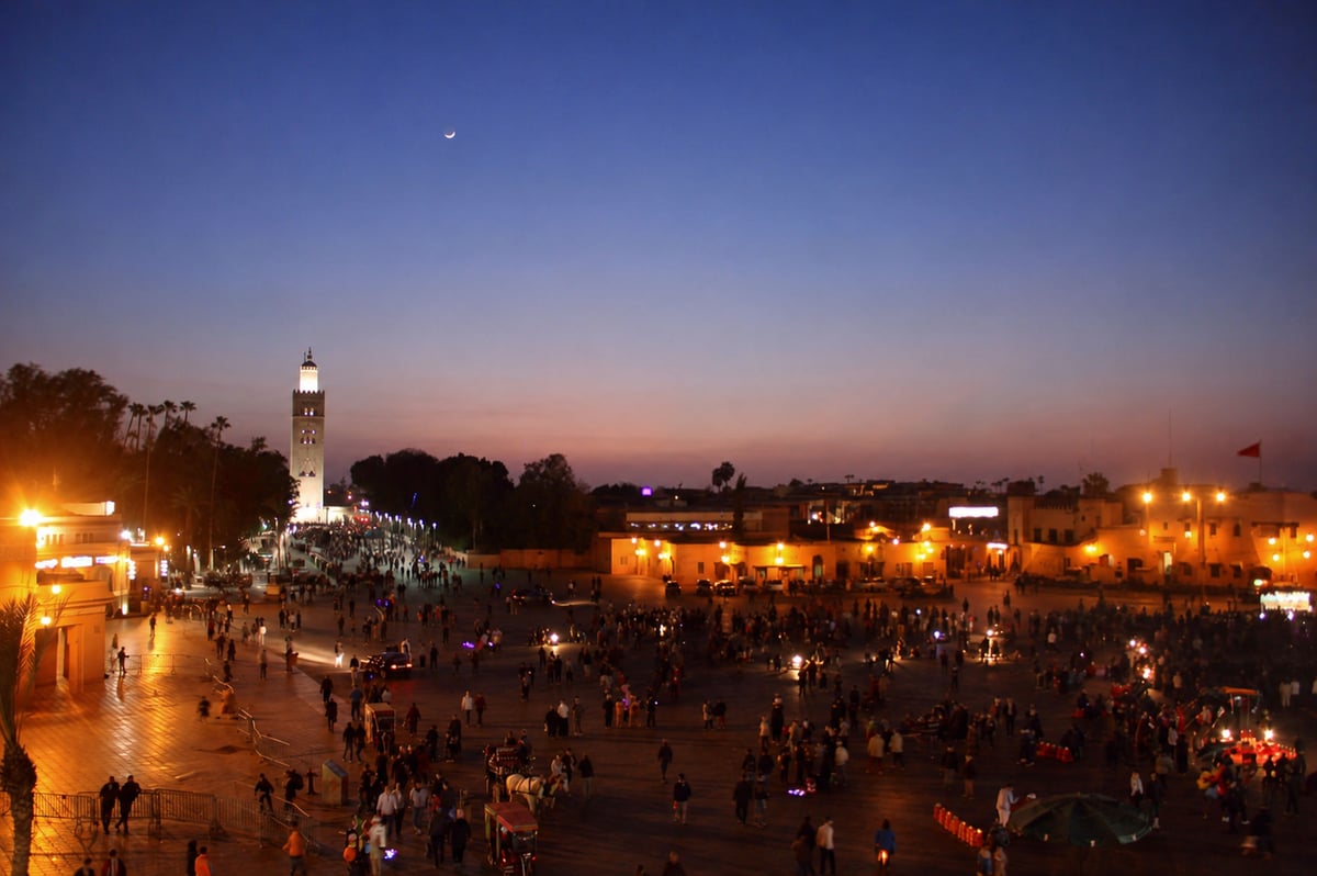 Jemaa el-Fnaa square at dusk with food stall smoke and crowds, no clear faces
