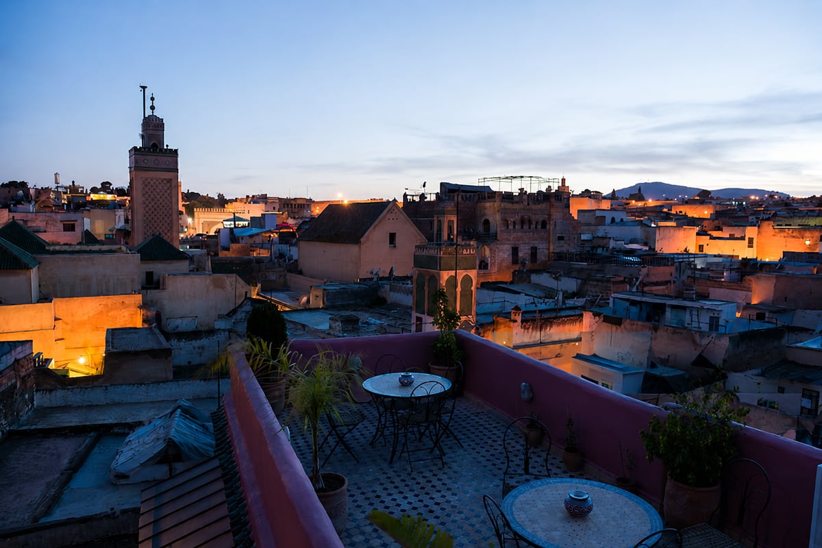 A Marrakech rooftop at golden hour with clear skies, no faces